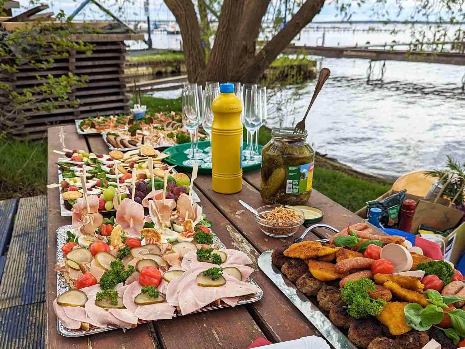 Auf dem Foto sieht man einen Tisch mit Platten auf denen Schnittchen und leckere Häppchen angerichtet sind.