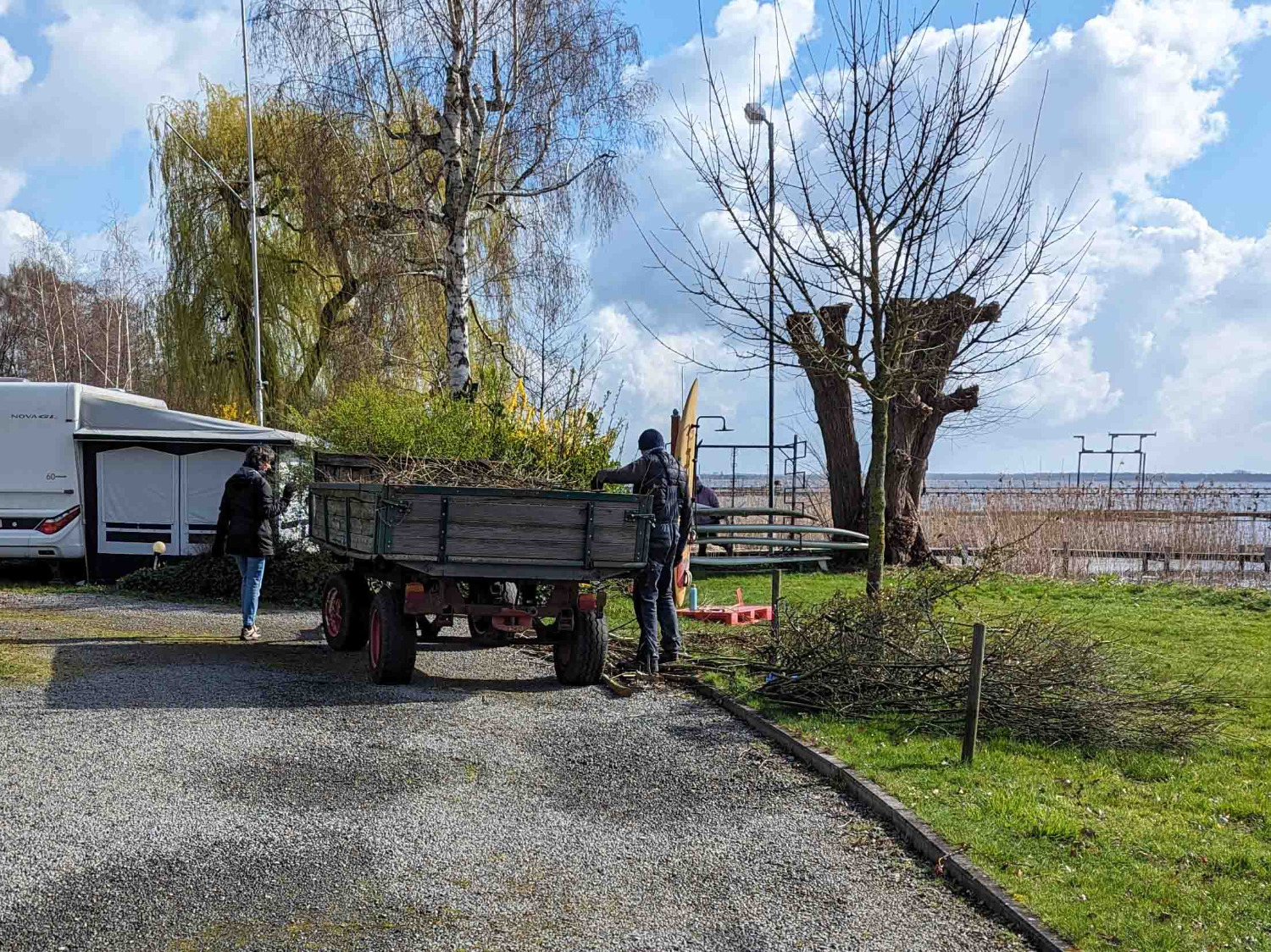 Zwei Mitglieder beladen Anhänger mit Laub und Ästen